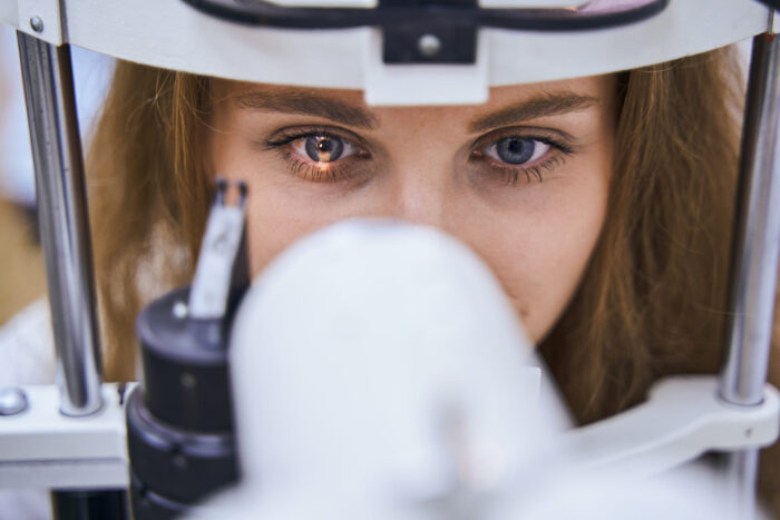 Young woman having eyesight examining in clinic